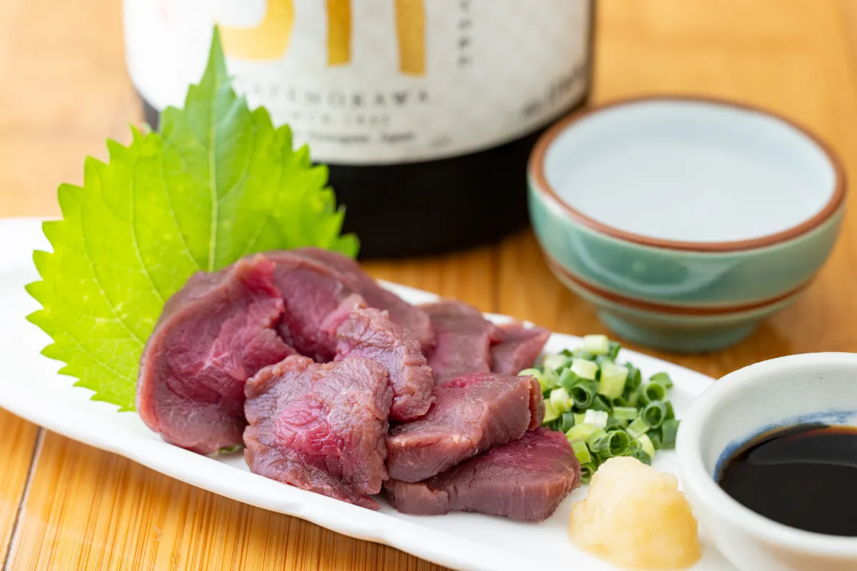 薬味を添えた赤身肉の刺身